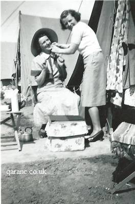 two nurses putting on bonnet WW2 outside tent